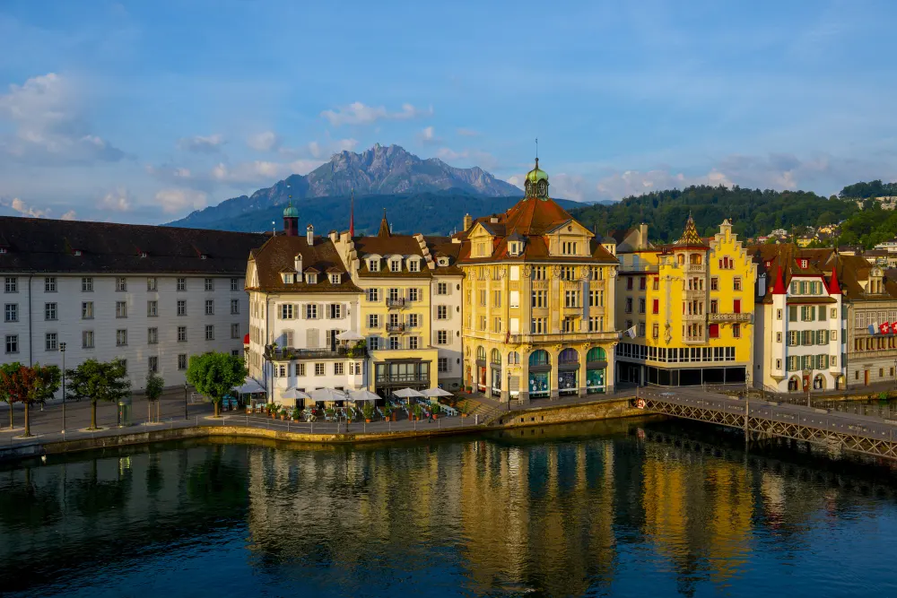 colorful-buildings-near-a-river-surrounded-by-mountains-in-lucerne-in-switzerland