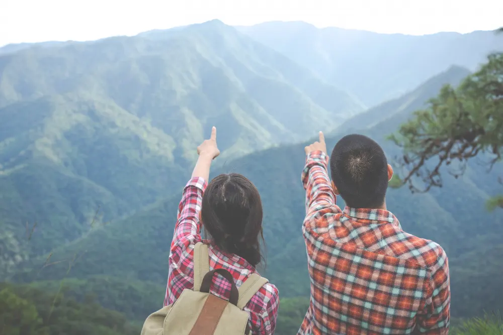 couples-pointing-to-the-top-of-the-hill-in-the-tropical-forest