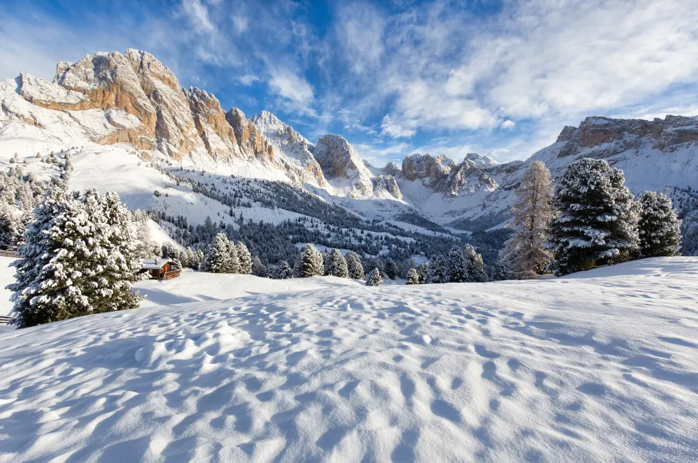 snowy-winter-landscape-with-houses- mountains-and-blue-sky