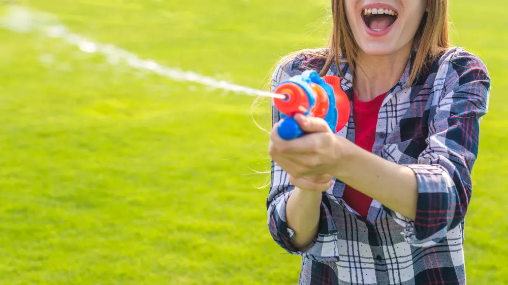 cheerful-girl-playing-with-water-gun