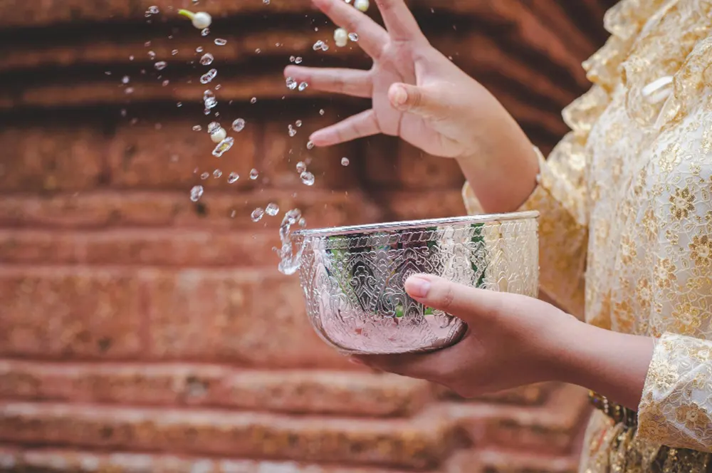 close-up-female-hand-holding-water-bowl-splashing