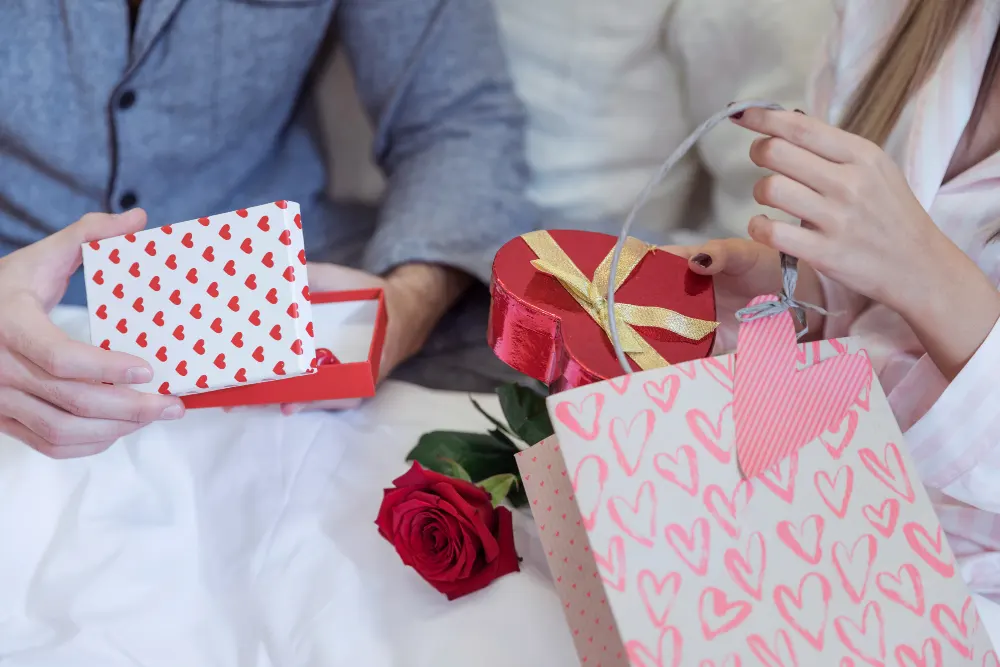 couple-pajamas-sitting-bed-with-gifts