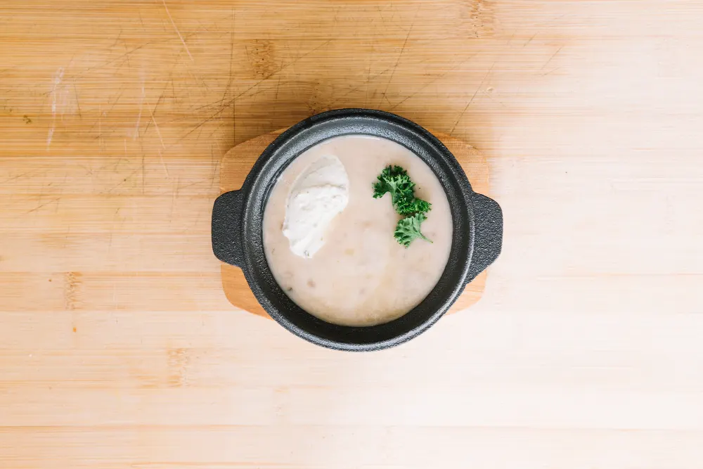delicious-mushroom-cream-soup-container-against-wooden-backdrop