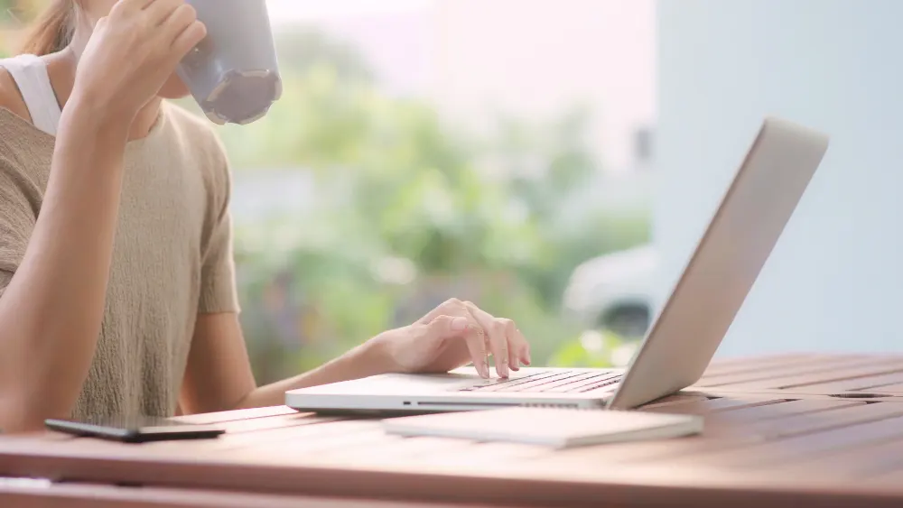 freelance-asian-woman-working-home-business-female-working-laptop-drinking-coffee-sitting-table-garden-morning