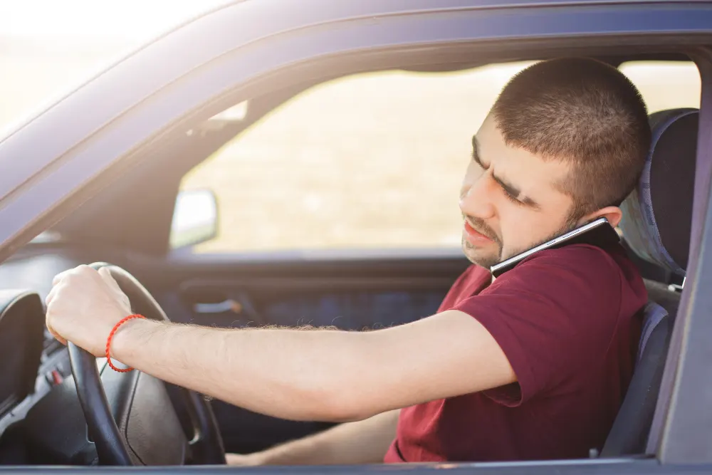 male-driver-with-concentrated-look-drives-car-talks-mobile-phone