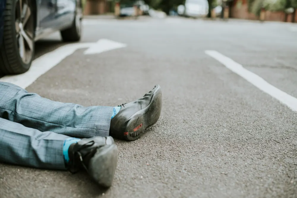 person-lying-ground-after-car-accident