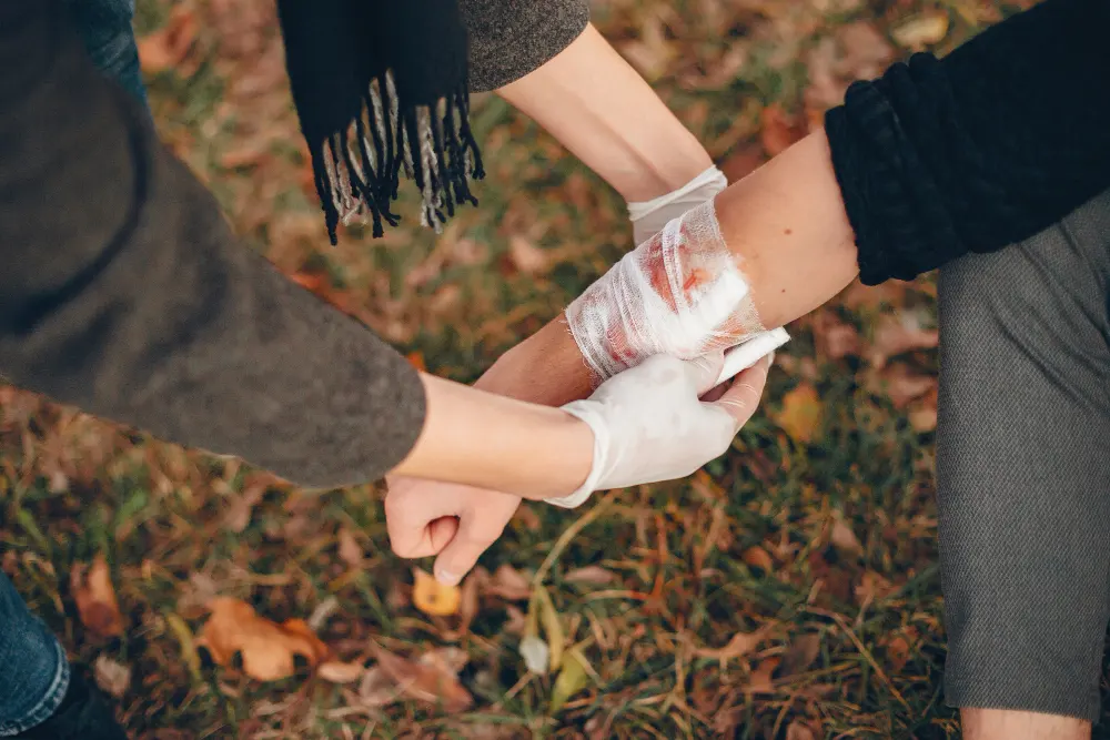 providing-first-aid-park-man-bandaged-injured-arm-guy-helps-friend