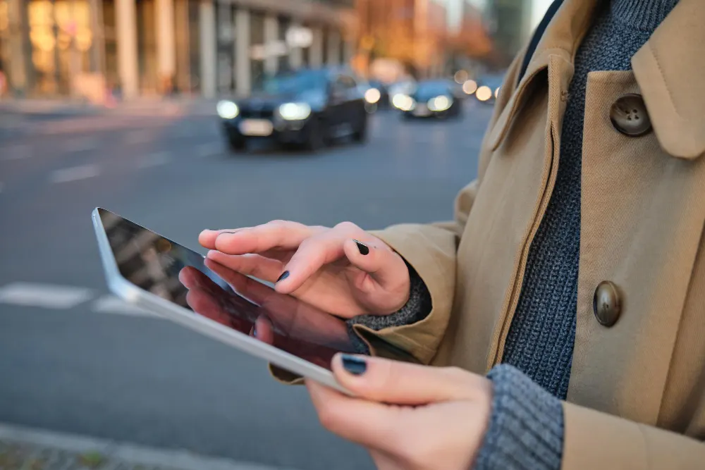 close-up-photo-of-female-hands-holding-digital-tablet-girl-looks-at-screen-checks-application-stands