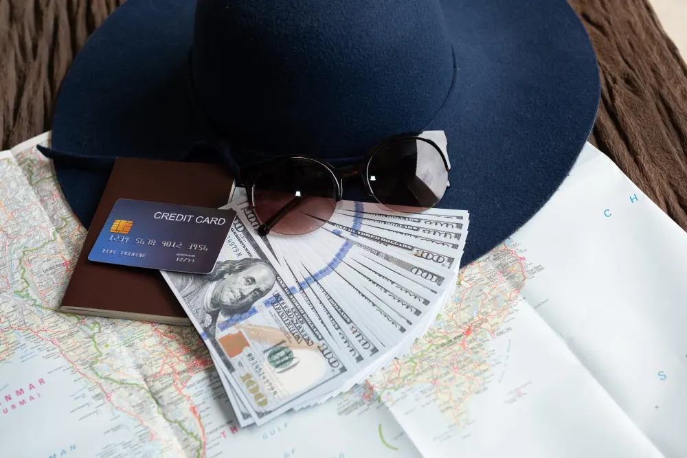 dollar-banknotes-sunglasses-credit-card-passport-and-blue-hat