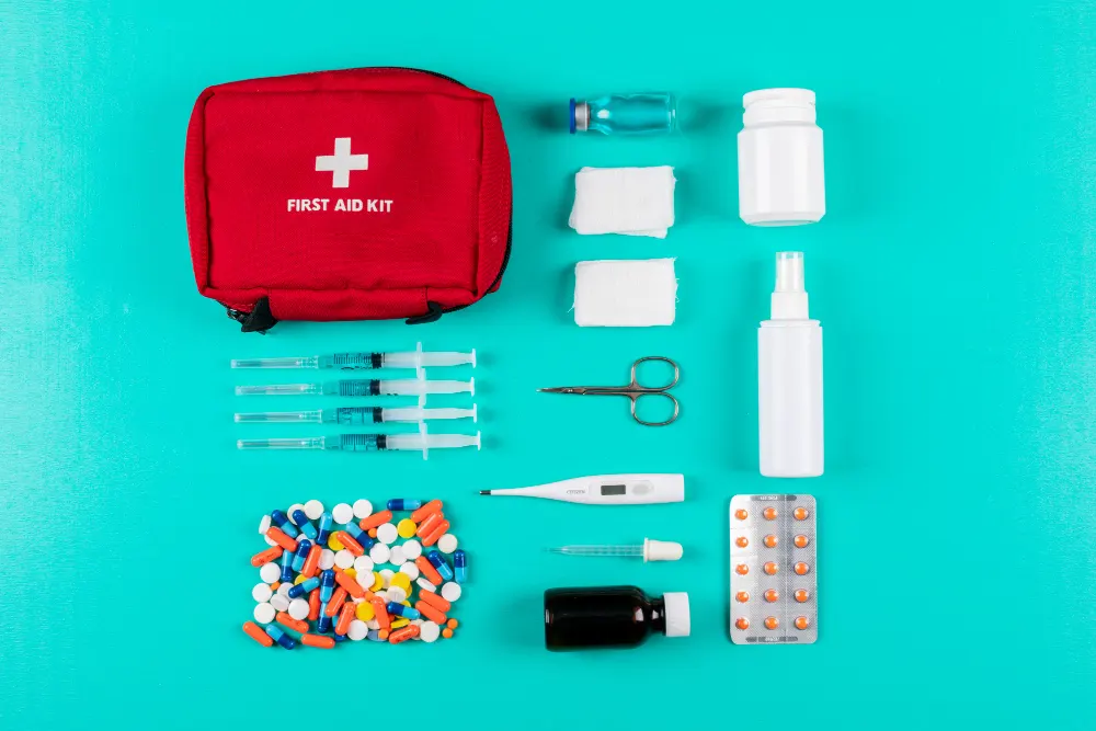 first-aid-kit-with-pills-thermometer-spray-pills-and-bandage- on-cyan