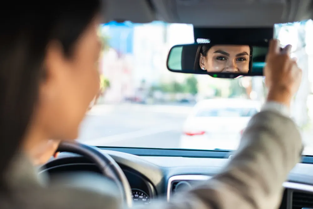 free-photo-businesswoman-adjusting-her-rear-view-car-mirror