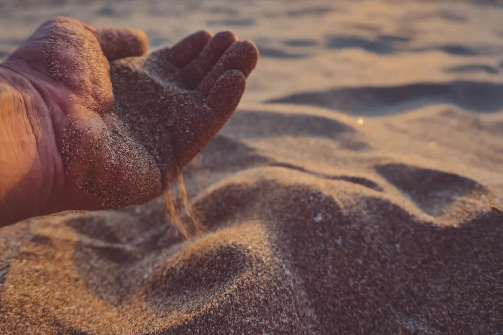 hand-pours-out-sand