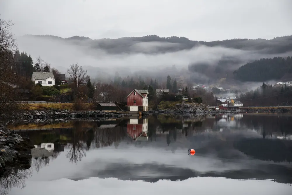 lake-surrounded-by-buildings-with- mountains-covered