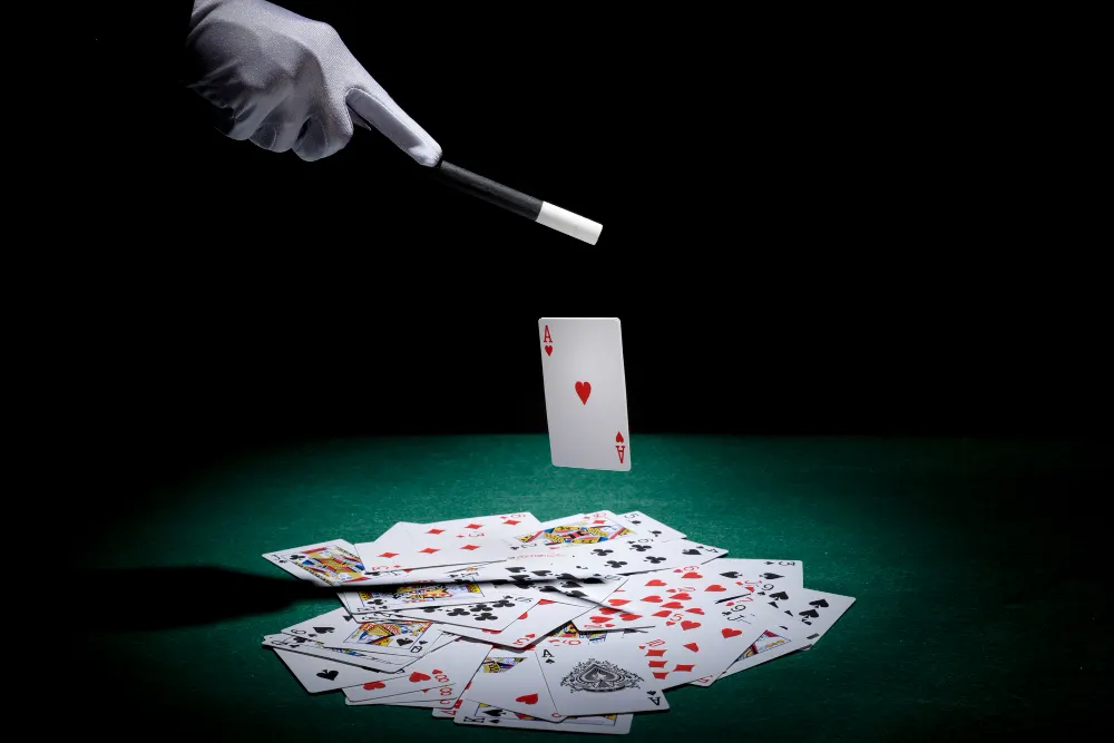 magician-performing-trick-on-playing-cards-with-magic-wand-on-poker-table