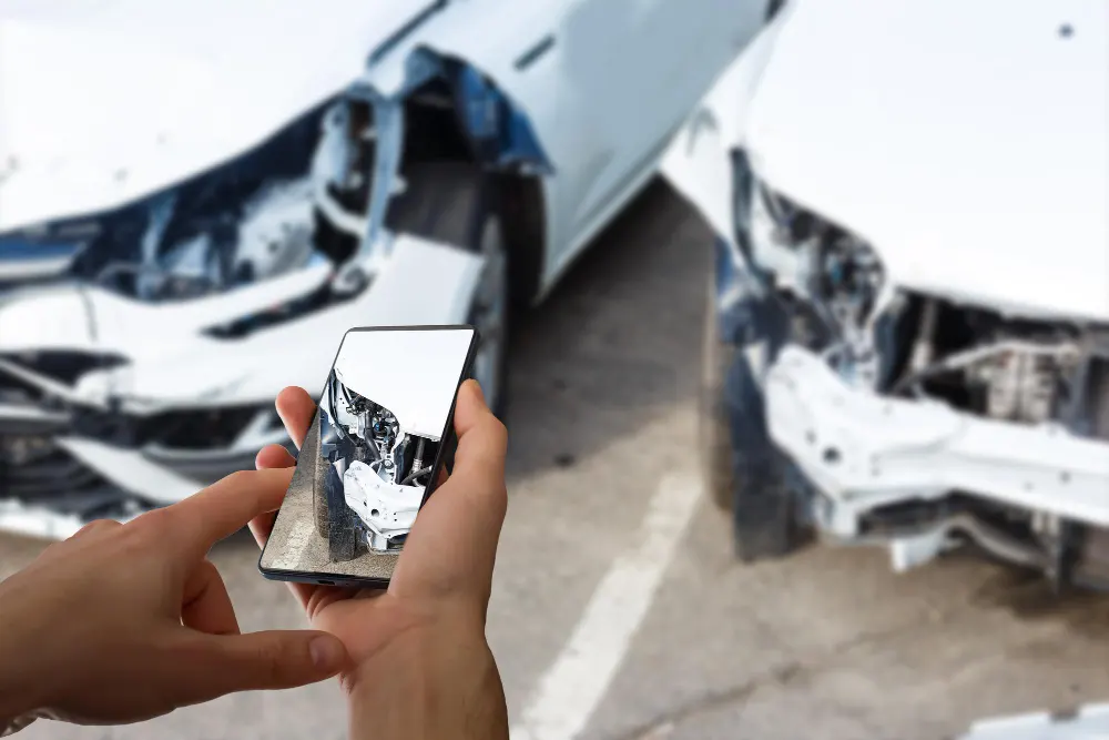 man-photographing-his-vehicle-with-damages-for-accident-insurance-with-smart-phone