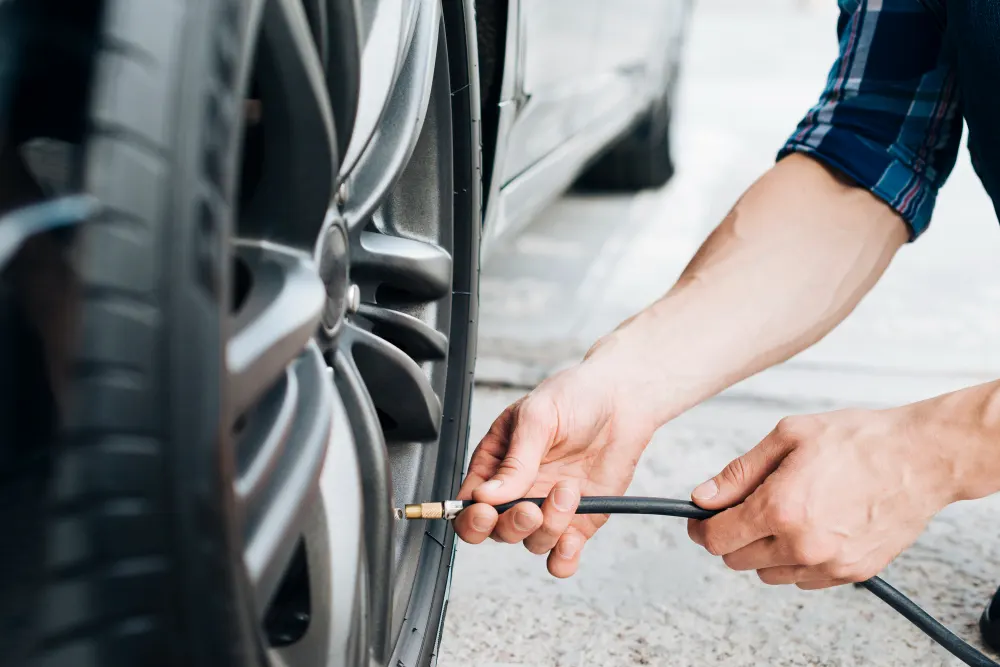 man-using-air-pump-on-car-wheel