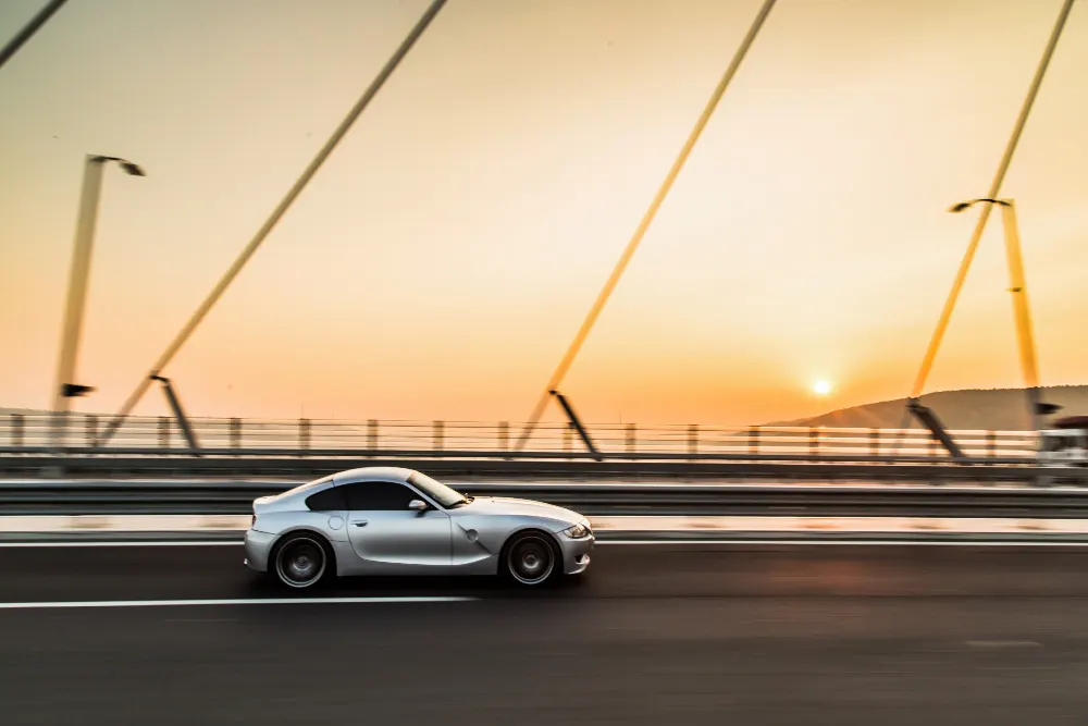 metallic-color-sport-car-on-the-bridge-in-the-sunset