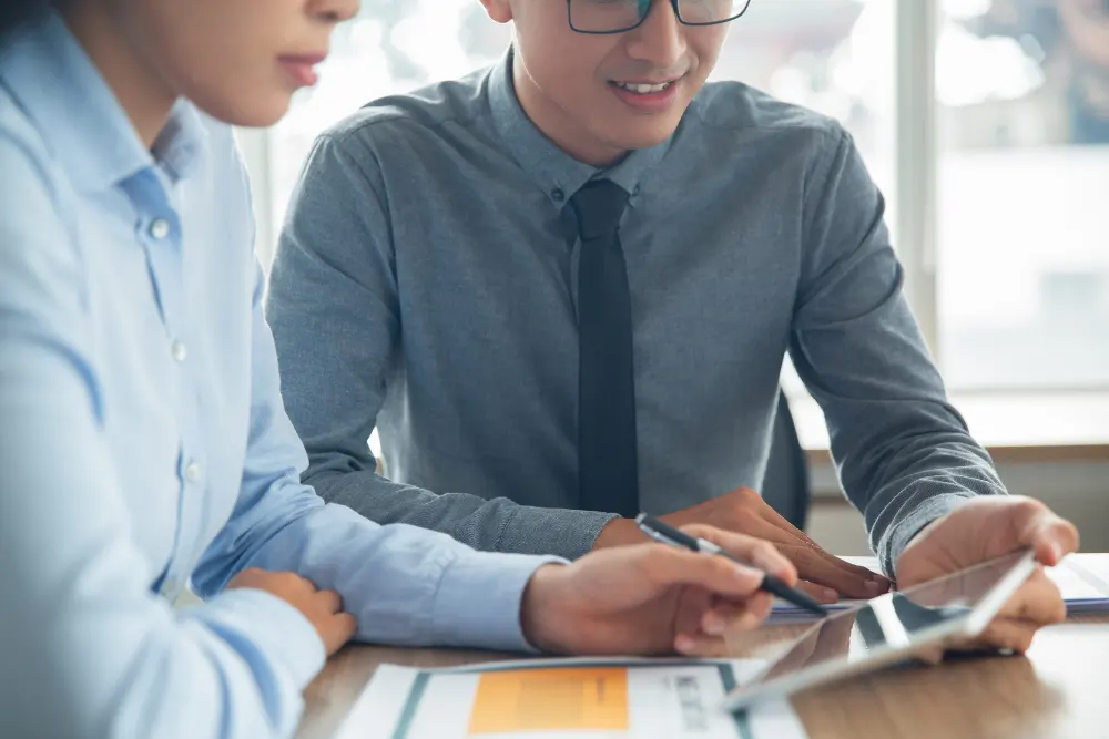 smiling-Asian-business-people-discussing-data