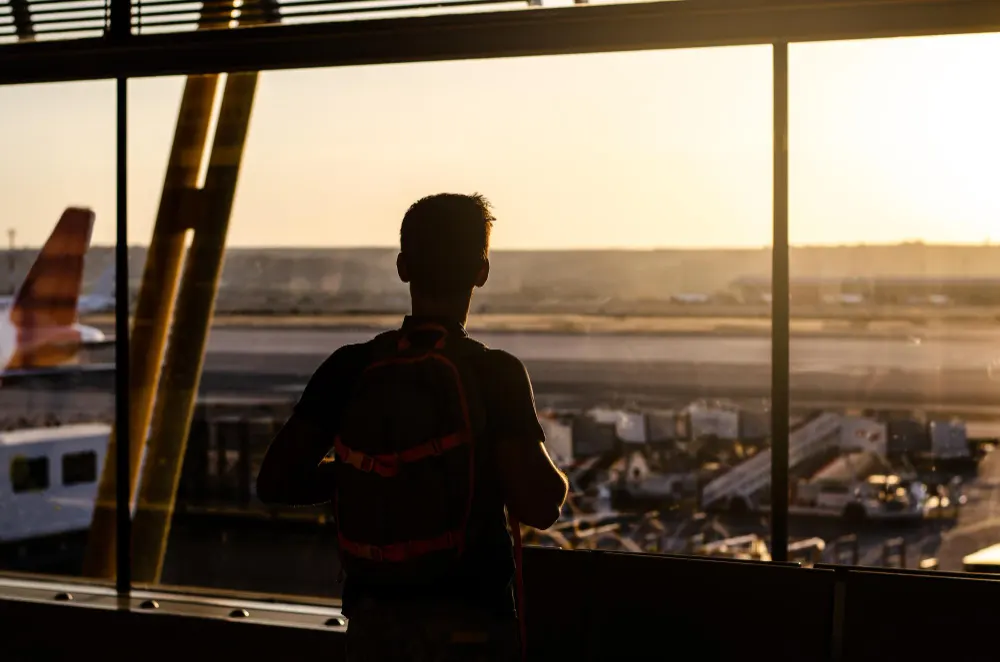 thoughtful-young-man-looking-by-the-window-at-a-airport-terminal