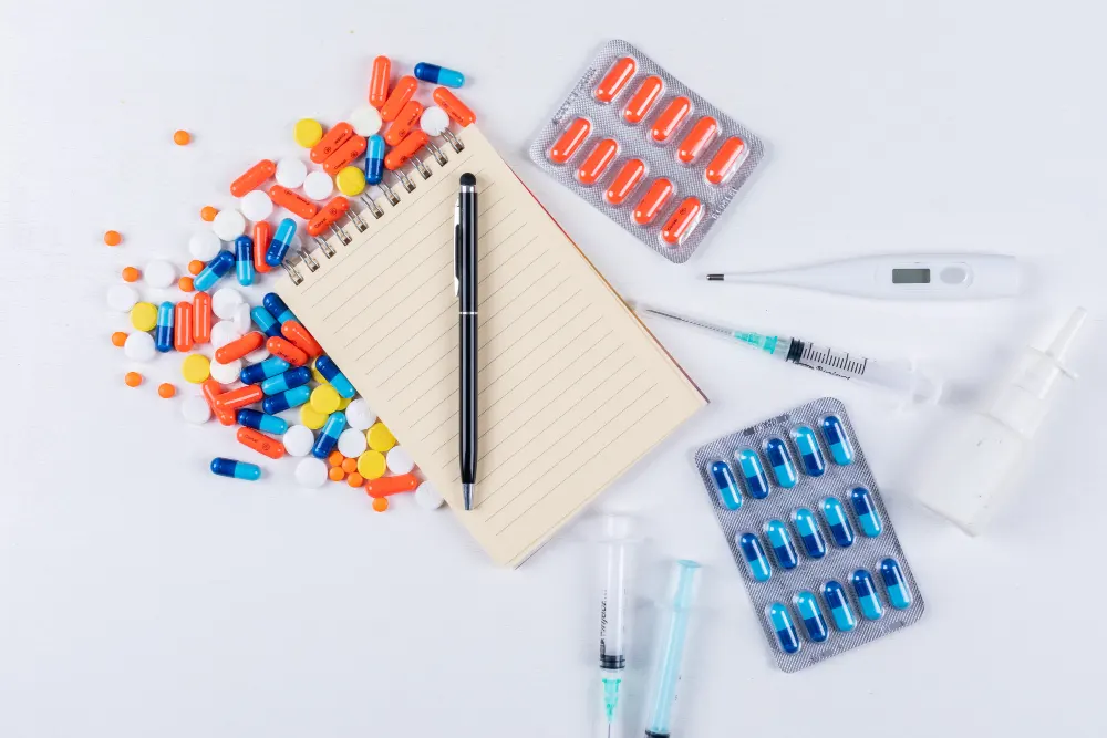 colorful-pills-with-notepad-pen-thermometer