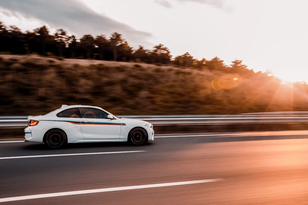 white-coupe-sedan-driving-on-the-road