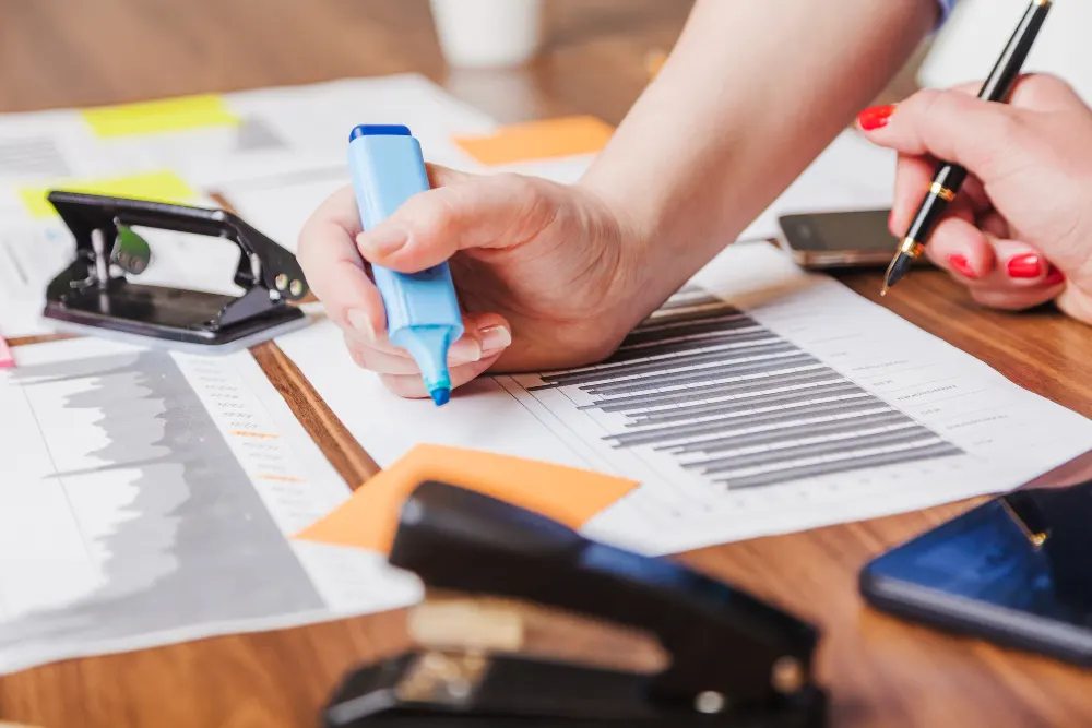 woman-holding-marker-pen-leaning-on-desk