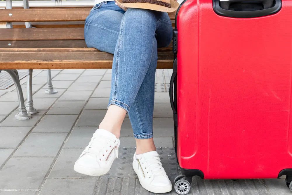 woman-sitting-on-a-bench-with-luggage