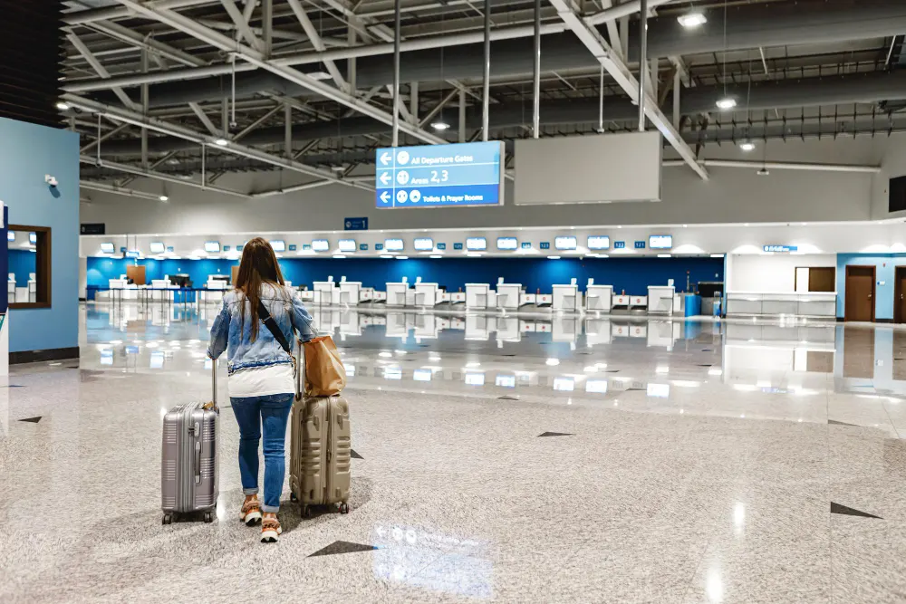 woman-walks-along-the-airport-with-suitcases