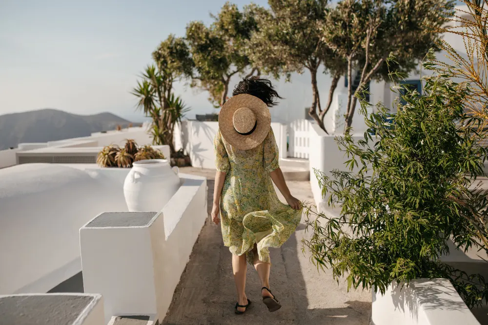 curly-short-haired-woman-floral-dress-boater-runs-outside