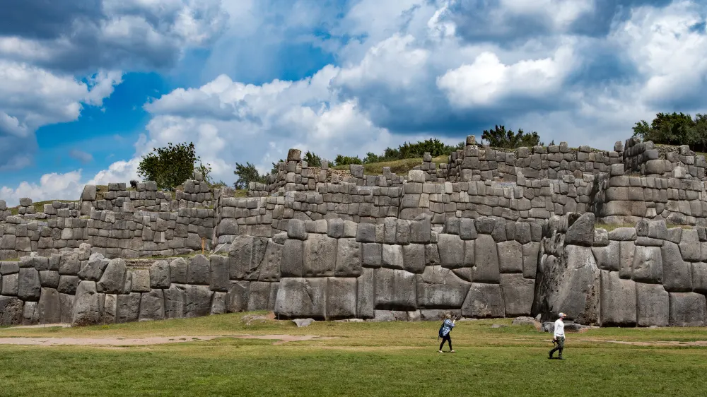 old-stone-wall-and-tourists-near-it-with-a-blue-sky