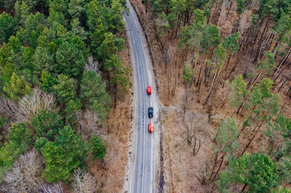 several-cars-with-kayaks-roof-rack-driving-road-among-trees