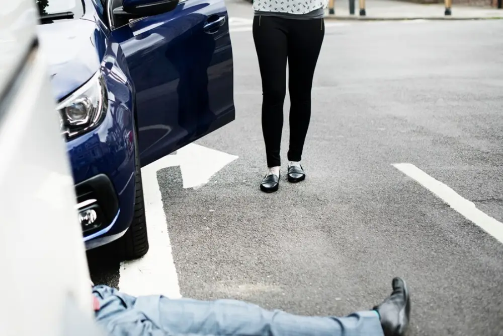 Person-lying-on-the-ground-after-a-car-accident