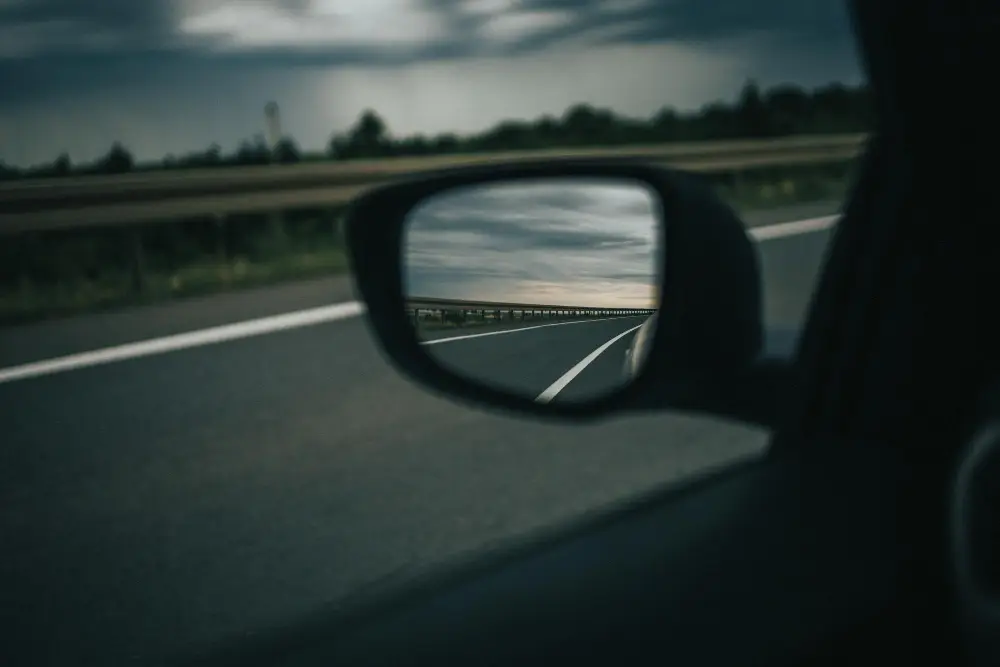 Selective-focus-shot-of-highway-reflection-on-a-car-side-mirror